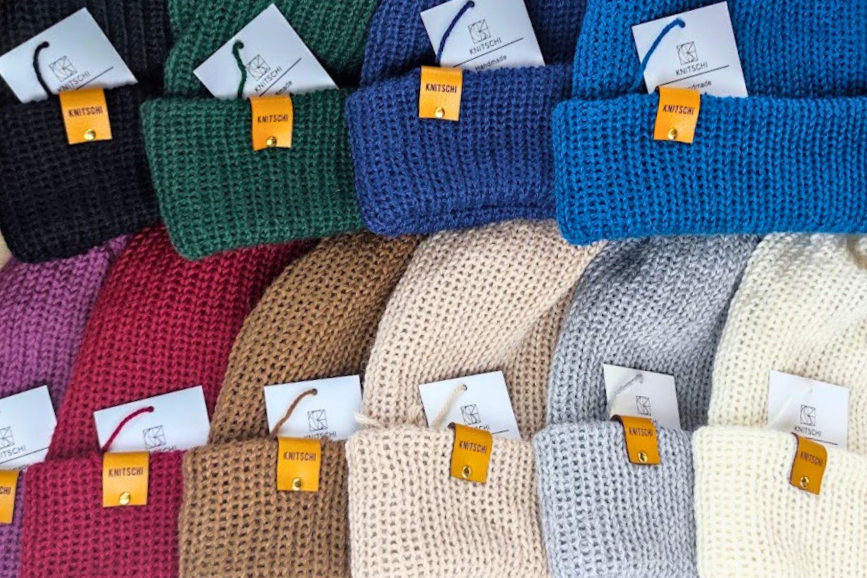 Mehrere KNITSCHI-Mützen in verschiedenen Farben aus der frühen Materialentwicklung